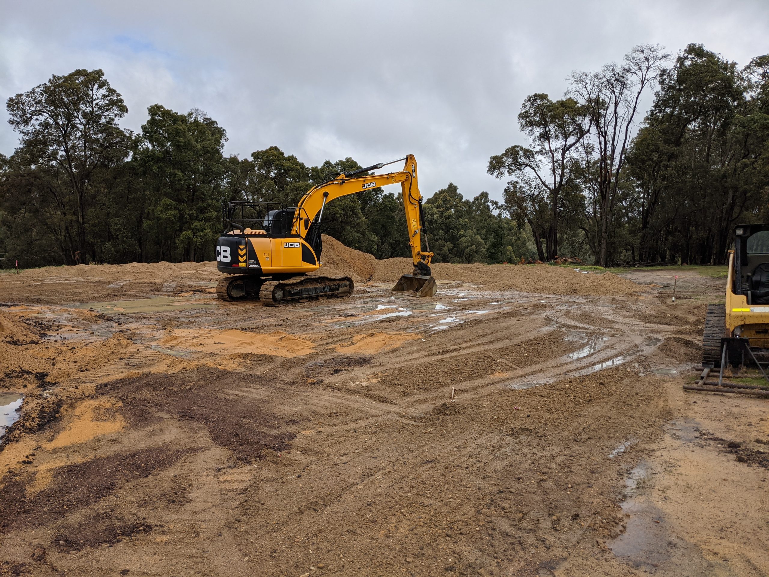 Excavator prepares the site before modules are landed